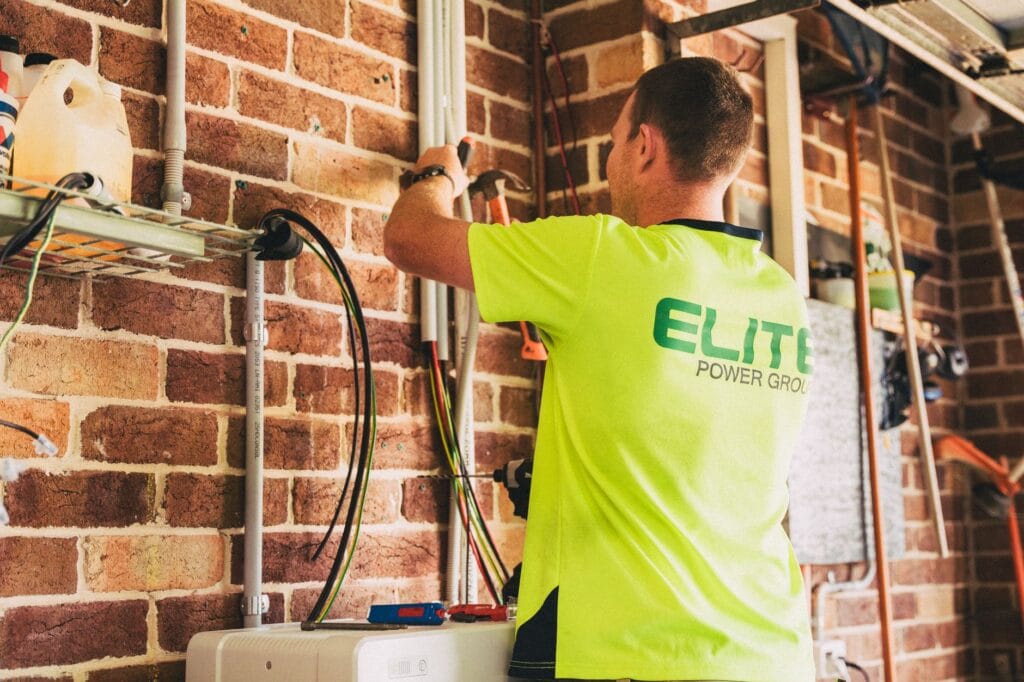 Elektryk montuje domowy magazyn energii do instalacji fotowoltaicznej